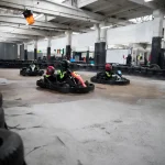 Karting Championship. Driver in karts wearing helmet, racing suit participate in kart race. Karting show. Children, adult racers karting.