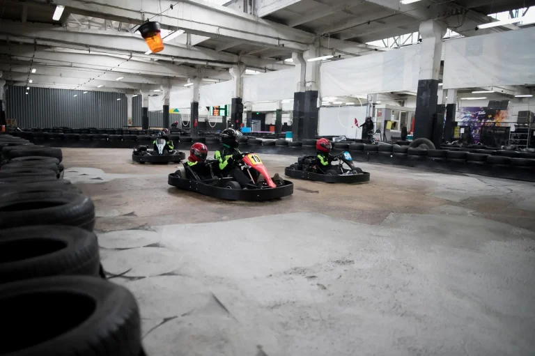 Karting Championship. Driver in karts wearing helmet, racing suit participate in kart race. Karting show. Children, adult racers karting.