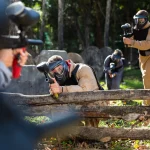 Portrait of team of adults playing on paintball battlefield outdoor