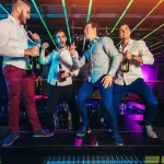 Group of smiling male friends having fun in night club