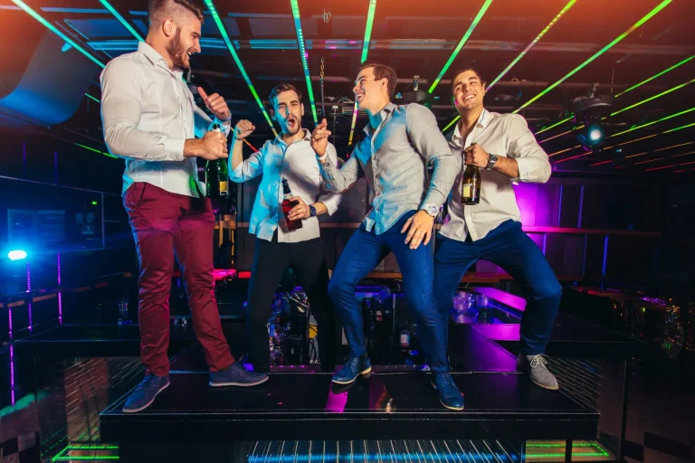 Group of smiling male friends having fun in night club